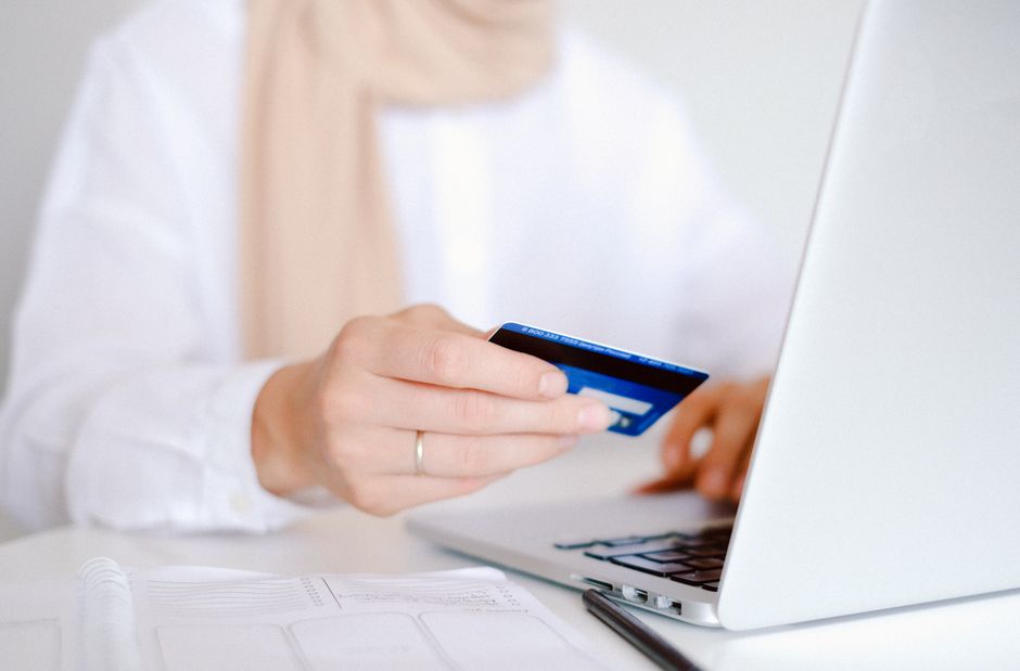 شخص يقوم بالدفع الإلكتروني عبر الكمبيوتر المحمول