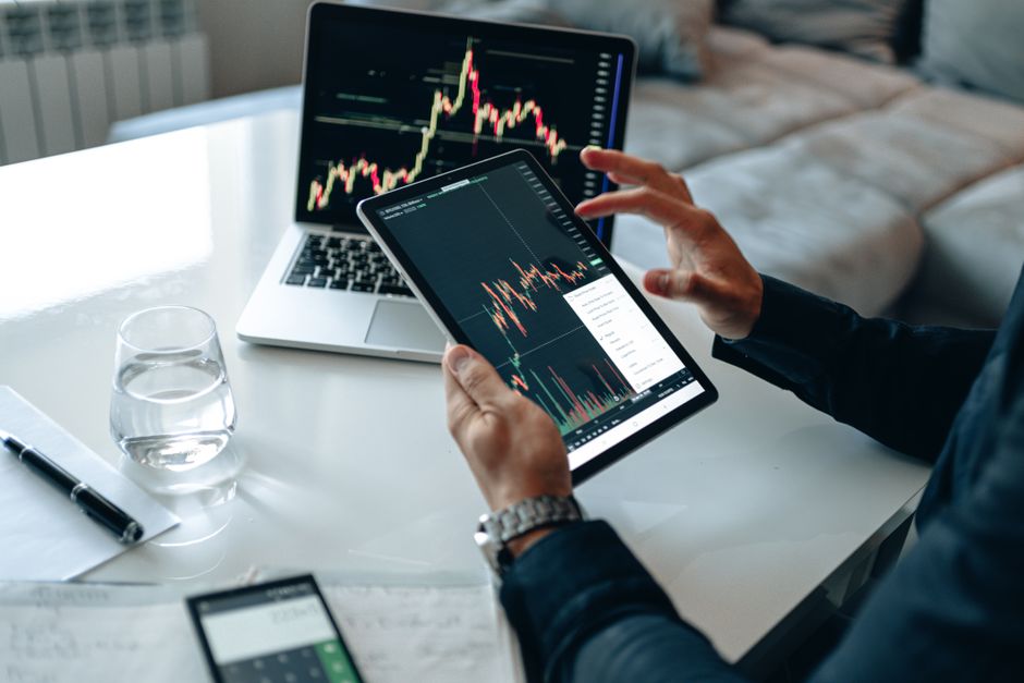 مستثمر يراجع البيانات المالية والتقارير على جهاز الحاسوب المحمول