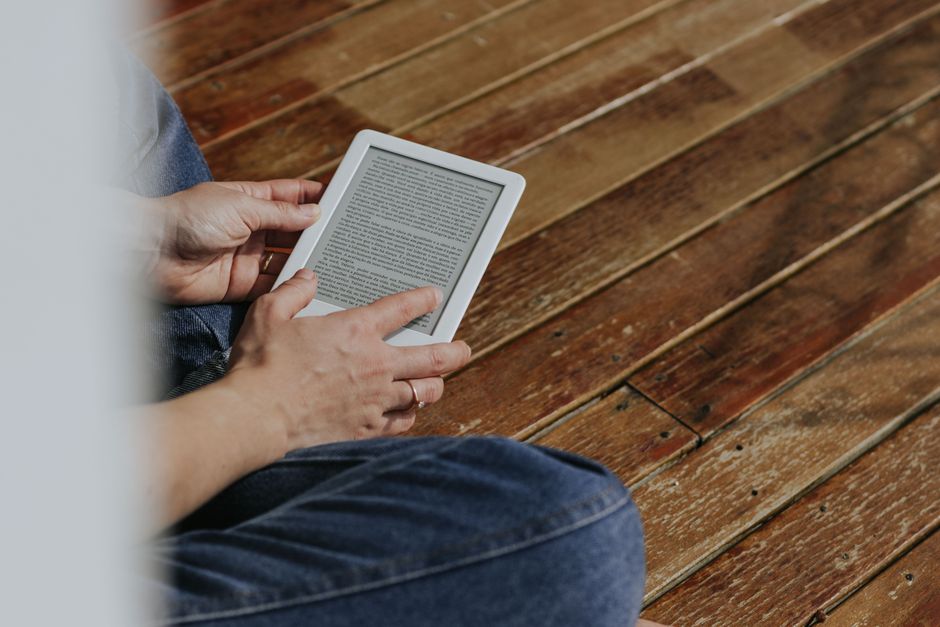 شخص يقرأ كتاباً إلكترونياً على جهاز قراءة حديث