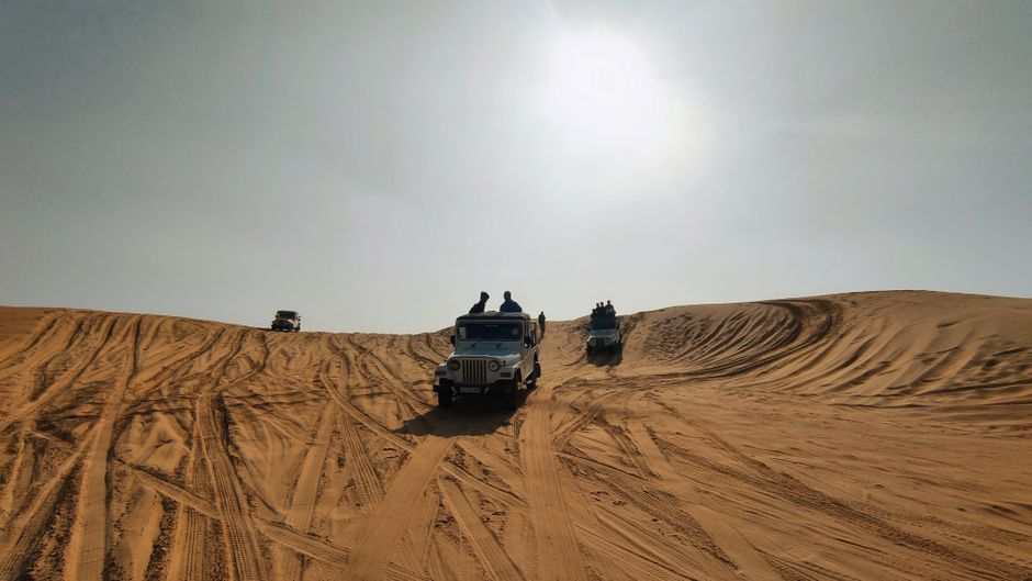 سيارة دفع رباعي تقوم بمغامرة فوق الكثبان الرملية في الصحراء الإماراتية