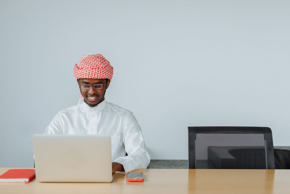 رجل سعودي يعمل على حاسوبه المحمول من المنزل