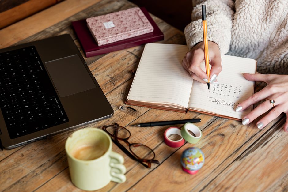 مكتب عمل منظم مع حاسوب محمول ومفكرة إنتاجية وفنجان قهوة