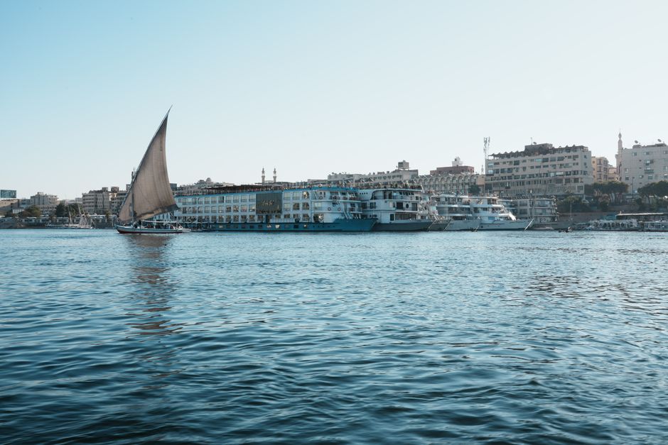 مراكب شراعية على نهر النيل في القاهرة مع خلفية الأبراج