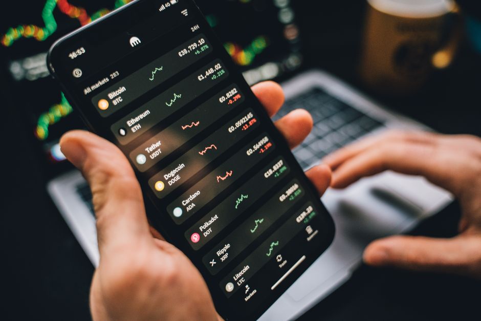 مستثمر يستخدم تطبيق تداول الأسهم على هاتفه الذكي في السوق السعودية