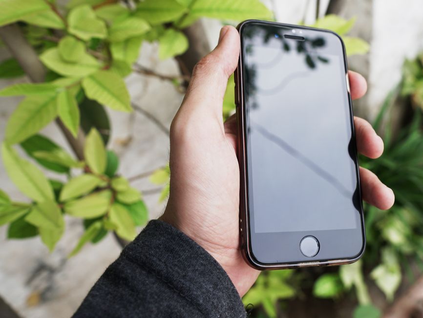 هاتف آيفون يعرض الشاشة الرئيسية لنظام iOS 19