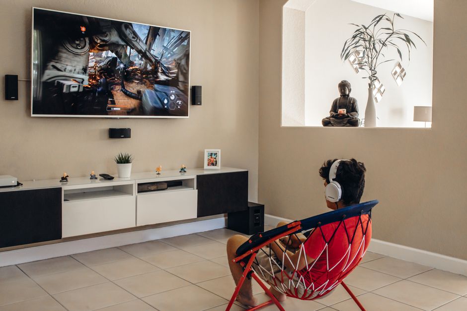 PS5 متصل بشاشة تلفزيون في غرفة المعيشة مع يد التحكم