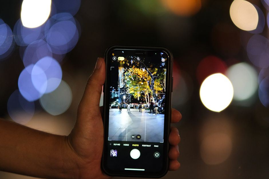 تصوير ليلي بهاتف ذكي في مدينة مضيئة