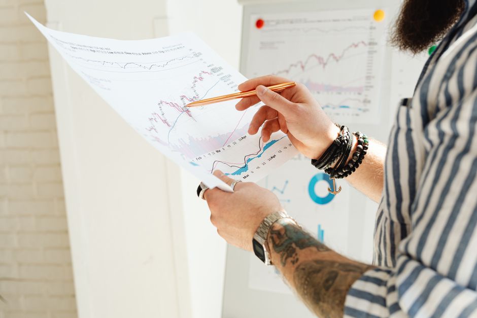 مستشار مالي يشرح لمستثمر سعودي مخططات بيانية داخل مكتب حديث