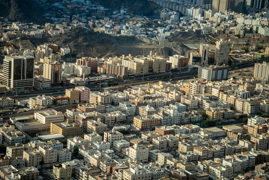 أفق مدينة سعودية حديثة مع أبراج تحت الإنشاء ورافعات بناء